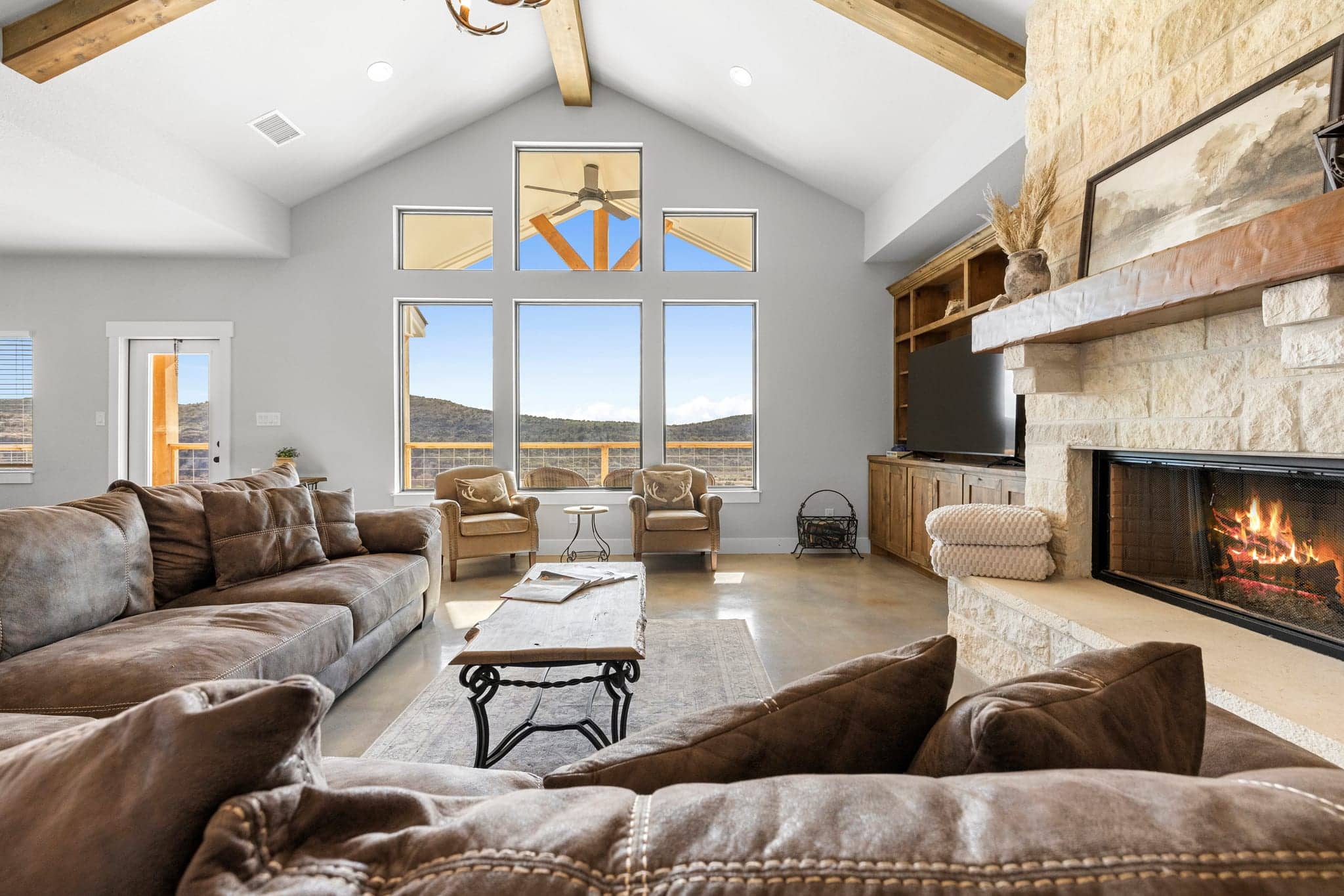 Bright Hill Country living room with a stone fireplace
