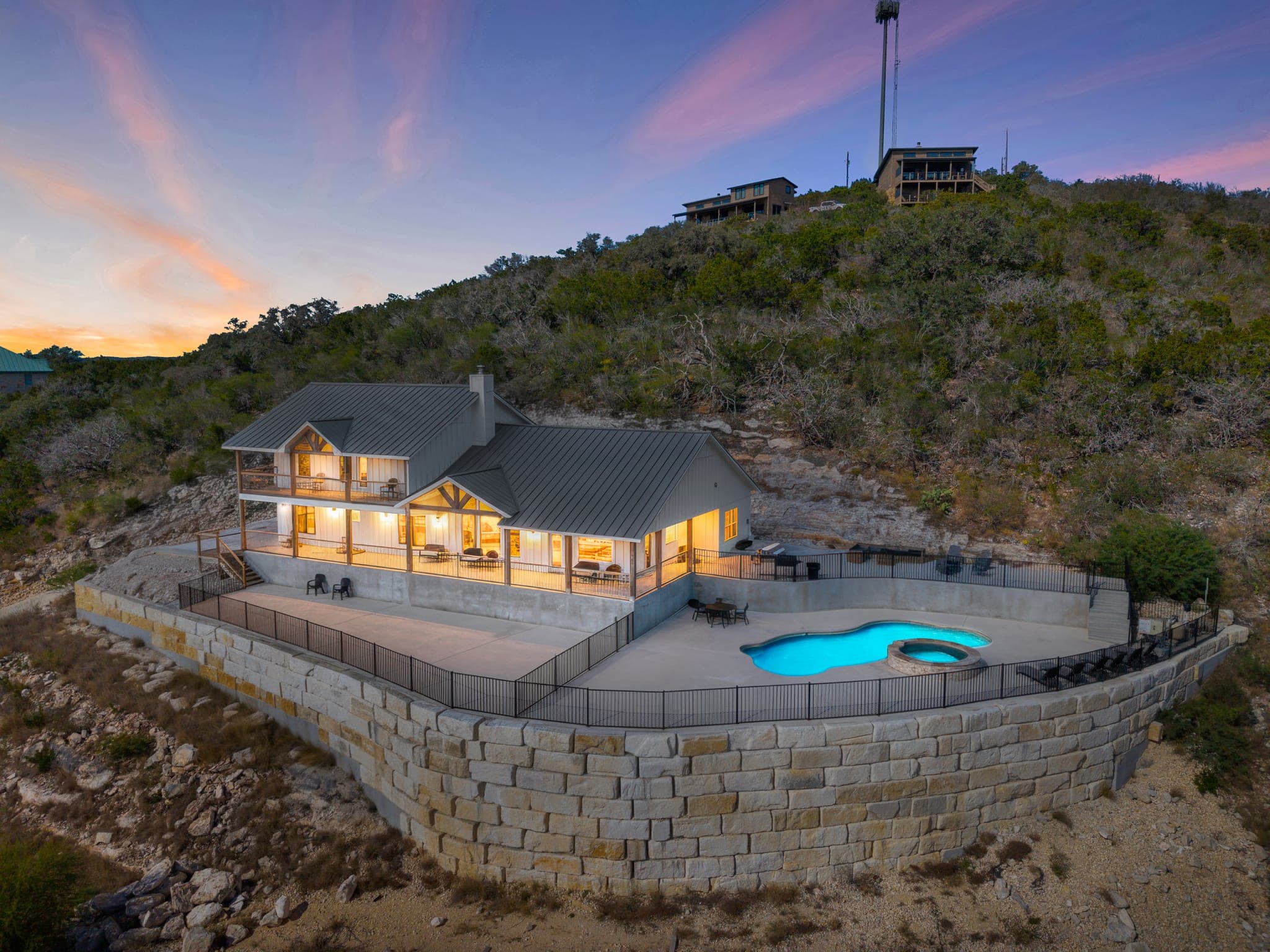 Aerial twilight view of a Hill Country home and pool