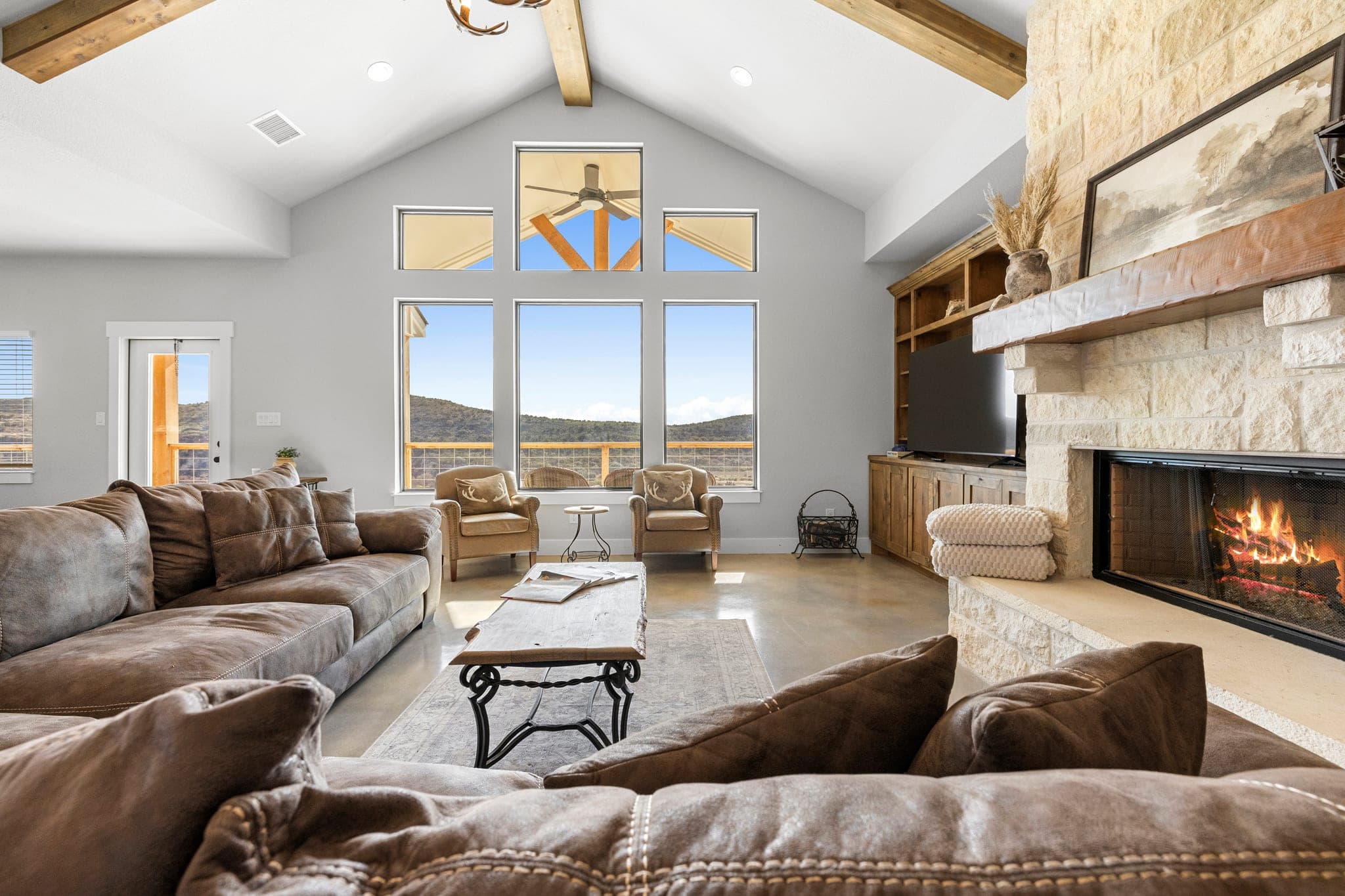 Bright Hill Country living room with a stone fireplace